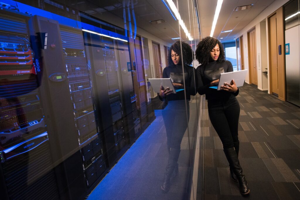 Imagem de mulher negra trabalhando com computador em servidores.